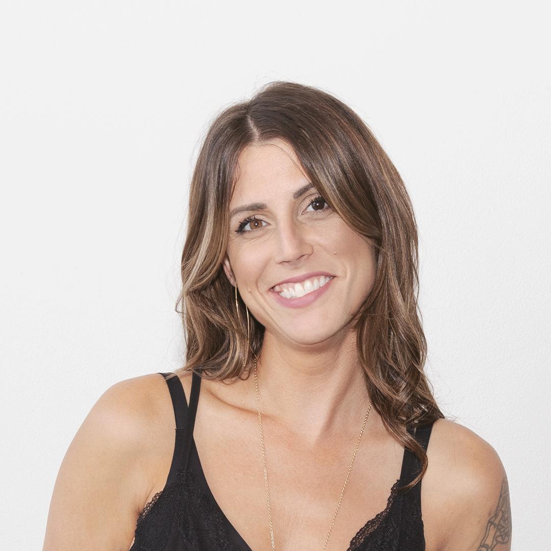 Erika Tontchev smiling in a professional portrait against a white backdrop